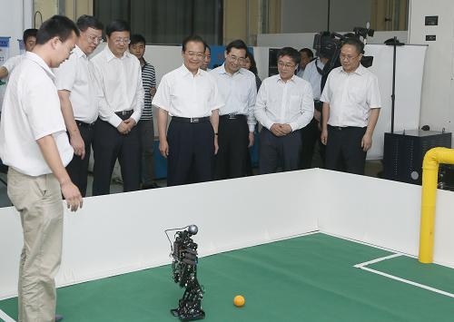 9月14日,中共中央政治局常委、國(guó)務(wù)院總理溫家寶應(yīng)邀到清華大學(xué)看望師生,并在學(xué)校大禮堂發(fā)表演講。這是溫家寶在機(jī)械工程學(xué)院制造系統(tǒng)實(shí)驗(yàn)室觀看學(xué)生們演示機(jī)器人踢足球表演。新華社記者 鞠鵬 攝