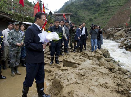 10月5日,中共中央政治局常委、國務(wù)院總理溫家寶趕赴云南省彝良縣山體滑坡現(xiàn)場,察看搶險(xiǎn)處置情況,慰問遇難人員家屬,考察受災(zāi)群眾安置點(diǎn),對搶險(xiǎn)救災(zāi)和災(zāi)后重建工作作出部署。這是10月5日,在龍海鄉(xiāng)鎮(zhèn)河村油房村,溫家寶緩步走到淹沒田頭小學(xué)的滑坡體前,向遇難的孩子和村民獻(xiàn)上一束菊花。新華社記者李學(xué)仁攝