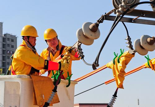10月17日,在天津市北辰區(qū),電力員工在帶電搭接10千伏高壓柔性電纜。新華社記者 張超群 攝