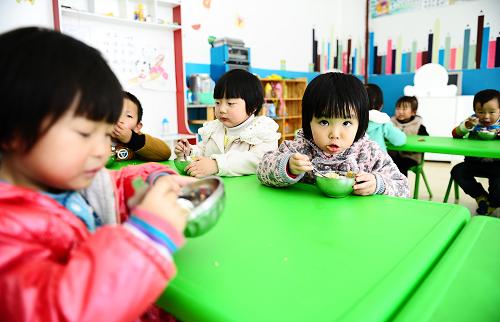 10月24日,格爾木市六一幼兒園小一班學(xué)生張舜博(右一)和同學(xué)一起在教室內(nèi)吃午飯。為改善當?shù)貙W(xué)前教育基礎(chǔ)設(shè)施薄弱的狀況,青海省海西蒙古族藏族自治州格爾木市自2010年起新建4所幼兒園,并購置玩具、教學(xué)設(shè)備,加強完善幼兒園基礎(chǔ)設(shè)施和配套設(shè)施建設(shè)。新建幼兒園占地超過28000平方米,總投資近8000萬元。“十二五”期間,格爾木市將新建20所幼兒園來滿足6000名幼兒的學(xué)前教育需求。