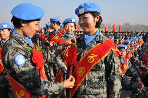 11月27日,在駐陜西某部隊營區(qū),兩名赴剛果(金)的維和官兵醫(yī)療分隊的女隊員在相互整理服裝。新華社發(fā)(武國強 攝)