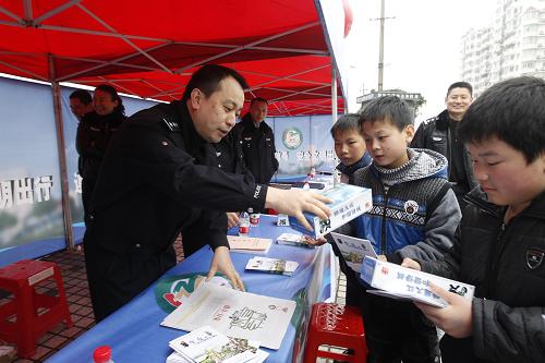 12月2日,在江西省九江市,民警朱曉明(左)向?qū)W生講解交通安全知識,并發(fā)放宣傳品。當日是首個“全國交通安全日”,各地開展交通安全日主題宣傳活動。今年全國交通安全日的主題為“遵守交通信號、安全文明出行”。新華社發(fā)(沈俊峰 攝)