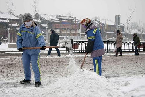 12月14日,在河北省承德市,環(huán)衛(wèi)工人在清理街上積雪。新華社記者 王昆 攝