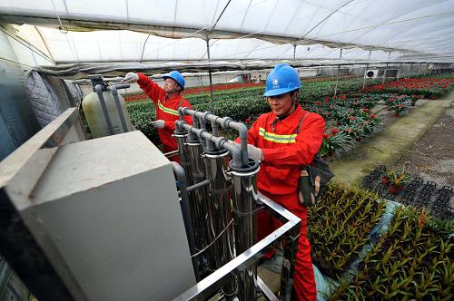 青州市供電公司“彩虹黨員服務隊”隊員為花農(nóng)安裝澆花凈水設備(12月12日攝)。山東青州是聞名的“中國花卉之鄉(xiāng)”,全市花卉種植面積11.8萬畝,花木生產(chǎn)專業(yè)村163個,從業(yè)人員11萬人,產(chǎn)值32億元。近年來,全市花卉專業(yè)化生產(chǎn)水平不斷提升,為確?;ɑ苌a(chǎn)日光溫室和高檔智能溫室等設施的用電安全,2012年國家電網(wǎng)青州市供電公司投資936萬元對花卉大棚低壓電網(wǎng)實施升級改造,并組建“彩虹黨員服務隊”深入花棚為種植戶服務,助推青州花卉產(chǎn)業(yè)迅猛發(fā)展。新華社記者 范長國 攝