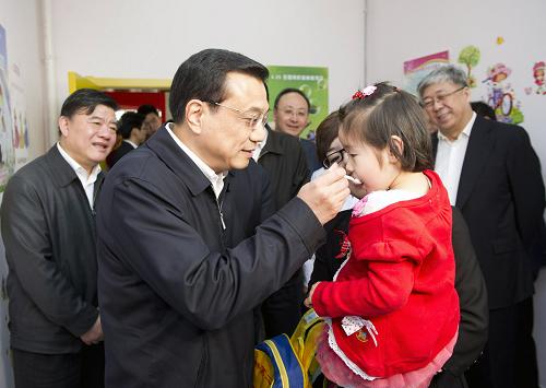 2011年4月25日,李克強參加2011年全國兒童預防接種日活動并考察北京市醫(yī)改工作。這是李克強在方莊社區(qū)衛(wèi)生服務中心喂孩子服食糖丸。新華社記者黃敬文攝
