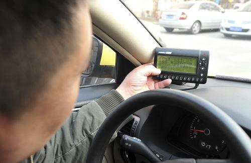 12月26日,河北唐山一名出租車司機展示帶有GPS定位的車載智能調(diào)度終端。新華社發(fā)(鄭勇 攝)