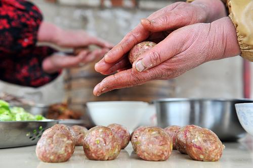 12月27日,蘇蘭花在搓肉丸子,肉丸子也是“九碗席”的“門子”菜里必備的食品。新華社記者 彭昭之?dāng)z