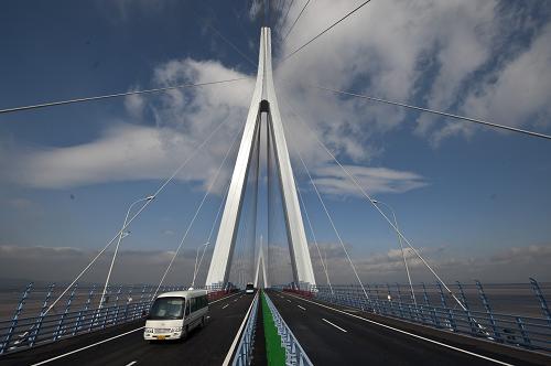 12月28日,車輛從寧波象山港跨海大橋的主橋面上通過。當日,浙江寧波象山港跨海大橋舉行簡短通車儀式,這是繼杭州灣跨海大橋、舟山跨海大橋之后,浙江省建成通車的第三座跨海大橋,大橋將于12月29日零時起正式試運營通車。 寧波象山港大橋及接線工程是浙江沿海高速公路(甬臺溫復線)的重要組成部分,全長約47公里,總投資約75億元,于2008年12月30日開工建設。 寧波象山港大橋及接線工程穿10座隧道,跨18座橋梁,建設難度大,技術要求高,通過11項自主創(chuàng)新取得六項“之最”:大橋主跨長達688米,是浙江省跨度最大的跨海大橋;大橋索塔總高度為225.5米,為同類橋梁浙江省最高;大橋設計抗風要求達到每秒46.5米,可抵抗14級臺風的沖擊,抗風能力為全國之最;大橋通航等級為5萬噸級,為全國最高;大橋主塔橋墩可抵御5萬噸級船舶撞擊,防撞等級國內最高;大橋通航凈高達53米,為國內最高。 大橋試通車后,寧波市將實現所有縣(市)區(qū)高速公路全覆蓋,象山縣城到寧波的距離也由目前的120公里縮短到52公里,車程由2小時變?yōu)?5分鐘。新華社記者 黃宗治攝