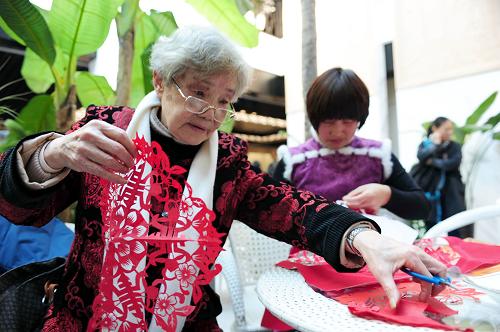12月28日,柘榮剪紙代表性傳承人袁秀瑩(左)等在現(xiàn)場(chǎng)表演剪紙。新華社記者林善傳攝