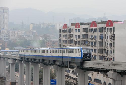 12月28日,一列跨座式單軌列車在城市建筑群中快速穿行。新華社記者 劉潺 攝
