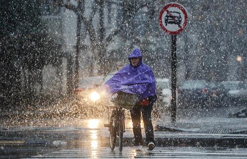 12月29日,一名騎車人在杭州市區(qū)內(nèi)冒雪推車前行。新華社記者 韓傳號(hào) 攝