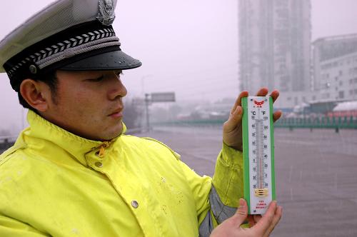 12月29日,江西省交警總隊(duì)二支隊(duì)一大隊(duì)的民警在測(cè)量橋面溫度。新華社記者 劉彬 攝