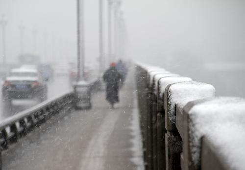 12月29日,行人和車輛在雪中通行南京長江大橋。新華社發(fā)(董金林 攝)