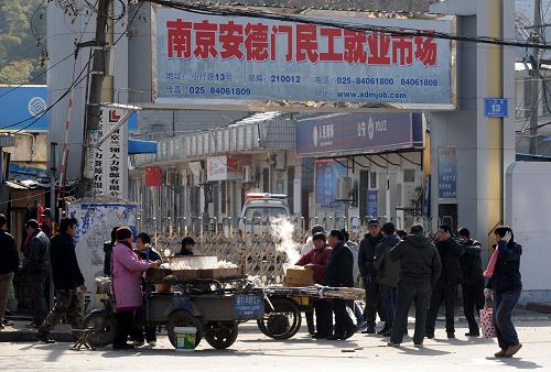 1月1日午飯時分,一些攤販在就業(yè)市場門前銷售食物。當(dāng)日,南京安德門民工就業(yè)市場放假歇業(yè)。市場附近的馬路邊和廣場上,許多外來求職的農(nóng)民工在“自娛自樂”和期盼中度過新年第一天。一旦有用工者出現(xiàn),他們都會蜂擁而上,爭相洽談。一名來自安徽的農(nóng)民工告訴記者,就業(yè)市場本周五才恢復(fù)營業(yè)。“新年要是找上一份好工作,就更讓人開心了。”記者了解到,農(nóng)民工大多謀求臨時工種,希望盡快找到合適的工作,掙些錢回家過春節(jié)。