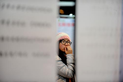 1月12日,一名應(yīng)聘者在招聘會上瀏覽招聘信息。 新華社發(fā)