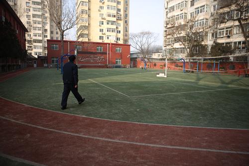 1月14日,上午課間操時間,一名保安走過北京涭水河小學(xué)操場。新華社發(fā)(劉長龍 攝)