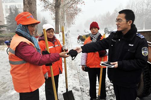 1月15日,山東鄒平縣環(huán)衛(wèi)部門工作人員上路給環(huán)衛(wèi)工增發(fā)口罩。新華社發(fā)(董乃德 攝)
