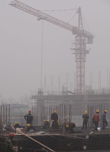 1月15日,鄭東新區(qū)的一個(gè)建設(shè)工地被霧霾籠罩。新華社記者 趙鵬 攝