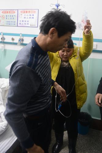 1月15日,一位受傷礦工在家屬協(xié)助下下床行走。新華社記者 林宏 攝