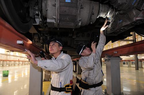 1月18日,兩名動車所地勤機械師在檢查入庫動車組走行部。新華社發(fā)(唐振江 攝)