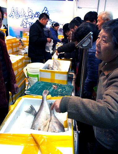 1月26日,許多顧客在釣魚島鮮魚攤位上挑選深海魚。新華社記者 陳飛 攝
