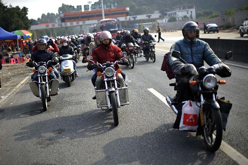 1月30日,騎摩托車返鄉(xiāng)人員行駛在321國道廣東封開段。新華社記者 吳魯 攝