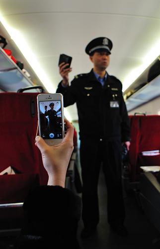 乘警長(zhǎng)楊振昌在G604次列車上為旅客表演順口溜(2月1日攝)。新華社發(fā)(王曉 攝)