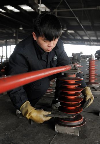 2月2日,鄭州鐵路局鄭州機務段的工作人員清潔春運機車組車頂?shù)慕^緣瓷瓶。新華社記者 李博 攝