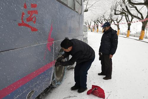2月8日,廬山汽車站工作人員在給廬山至九江的班車安裝防滑鏈條。新華社發(fā)(秦永言 攝)