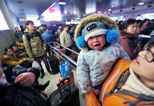 2月8日,在南昌火車站候車大廳內(nèi),一位兒童正在母親懷里候車。新華社記者 彭昭之 攝