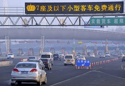 2月9日早晨,大批小型客車免費通過大連收費站駛?cè)肷蚝8咚俟贰P氯A社發(fā)(劉德斌 攝)