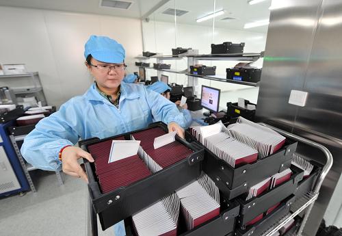 3月8日,重慶出入境管理局制證中心的制證員秦夢影在對制作完成的成品護(hù)照進(jìn)行裝箱清點(diǎn)。當(dāng)日是“三八”婦女節(jié),重慶出入境管理局制證中心的姑娘們堅(jiān)守在自己的崗位上,為護(hù)照、港澳通行證的申辦者們趕制證件。她們的工作往往不為人所知,但是重慶市每一個護(hù)照、港澳通行證申報(bào)者的證件都是由她們精心制作出來的。今年以來,重慶申辦護(hù)照和港澳通行證的人數(shù)激增,制證中心的姑娘們工作量急劇增加,16個姑娘加上幾名男同志每天需要制作近8000本護(hù)照和港澳通行證。最忙的時候,她們每人每天需要穿著悶熱的防塵服在無塵車間里工作超過10個小時,盯著電腦屏幕核對信息上千次,手上機(jī)械地重復(fù)單一動作2000多下。在姑娘們的眼中,每本護(hù)照的背后都有一個故事,她們希望通過自己的辛勤工作,讓這個故事盡快回到講述者的手中,方便他們能夠圓夢。制證員秦夢影說,工作對她而言,不僅僅只有辛苦,還有快樂,那些申辦者拿著制作精美的證件走出國門周游列國享受幸福快樂的時候,是她和姐妹們最有成就感的時刻。