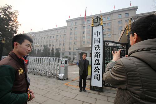 3月17日,一名男子在中國鐵路總公司門牌前留影。當日,“中國人民共和國鐵道部”的門牌被換為“中國鐵路總公司”門牌,不少群眾在門牌前拍照留念。新華社發(fā)