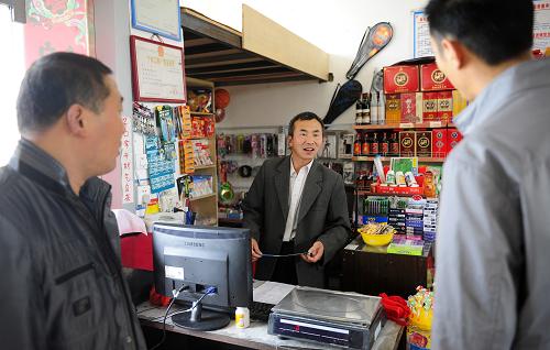 黃湖移民新村的王浦利(中)在村里開起了超市,每年可以收入七八萬元(4月19日攝)。2010年5月,位于南水北調(diào)丹江口庫區(qū)的湖北省鄖縣800多戶、3700多名村民搬遷到湖北省團風(fēng)縣黃湖移民新村。他們從千里之外的庫區(qū)搬到一個陌生的新家,從排斥到欣然接受,從不適應(yīng)到適應(yīng)。如今3年將滿,村里不僅增加了用于發(fā)展的80多臺大型運輸車,而且還添置了十幾臺小轎車。勤勞的移民們正在為發(fā)展致富的目標(biāo)努力著。