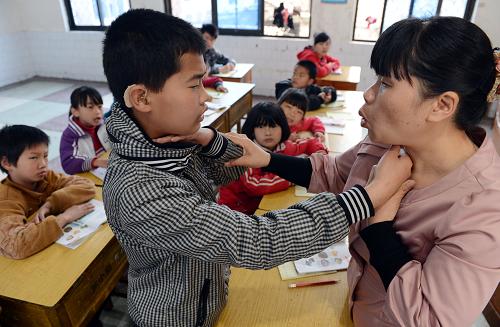4月25日,劉小清(右)在指導(dǎo)啟音班13歲的吳國良(前左)感受聲帶振動(dòng)進(jìn)行發(fā)音練習(xí)。江西蘆溪縣特殊教育學(xué)校特教老師、共產(chǎn)黨員劉小清,16年來以“母愛、友愛、師愛”有機(jī)融合,用微笑傳遞知識(shí),用耐心和愛心為殘疾學(xué)生搭起追尋夢(mèng)想的舞臺(tái),先后獲得全國優(yōu)秀教師、全國優(yōu)秀班主任等稱號(hào)。新華社記者 宋振平 攝