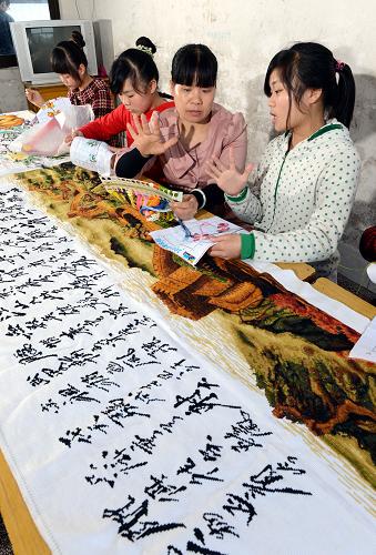 4月25日,劉小清(右二)正在指導(dǎo)啟音班15歲的王迎春(右一)等聾啞學(xué)生練習(xí)十字繡。新華社記者 宋振平 攝