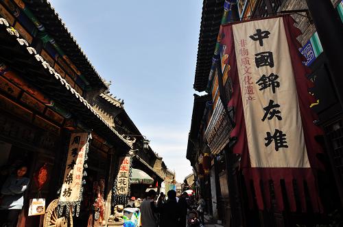 4月29日,游客在周村古城景區(qū)游玩。自2011年3月開始,山東省淄博市周村古城景區(qū)開始免除門票,游客可以自由出入景區(qū)內(nèi)的大街、銀子市街、絲市街等主要景點(diǎn)。兩年來(lái),景區(qū)依靠提升服務(wù)質(zhì)量、增加服務(wù)設(shè)施等措施,吸引了更多商家進(jìn)駐古城,也帶動(dòng)了周邊游客到古城旅游。門票免費(fèi)的政策使游客比收票前增加了四成,其在周村吃、住、游、購(gòu)的消費(fèi)大大增加了當(dāng)?shù)夭惋嫛?huì)展、娛樂(lè)、文化、商鋪等各業(yè)的收入,使景區(qū)旅游擺脫了門票經(jīng)濟(jì)的限制,朝著更加多元的方向發(fā)展。
