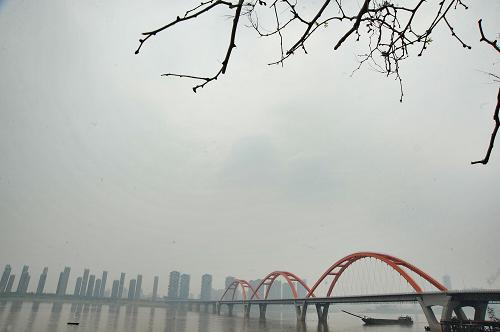 霧霾籠罩下的長沙福元路大橋附近湘江主航道(5月5日攝)。 當日,湖南長沙霧霾罩城,市區(qū)能見度差,給市民出行和健康帶來不利影響。記者從相關部門獲悉,今年1至3月,已經實施新《空氣質量標準》的長沙市、株洲市和湘潭市城市環(huán)境空氣質量總體達標比例僅為30.7%,灰霾防治工作刻不容緩。湖南目前擬出臺強化工業(yè)污染防治、發(fā)展綠色交通等8項措施,推進霧霾污染治理,改善大氣環(huán)境質量。 新華社記者 龍弘濤 攝