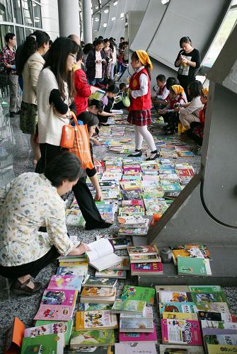 5月5日,學(xué)生和家長在第八屆南京市中小學(xué)生舊圖書交易節(jié)上選購圖書。新華社發(fā)(王新 攝)