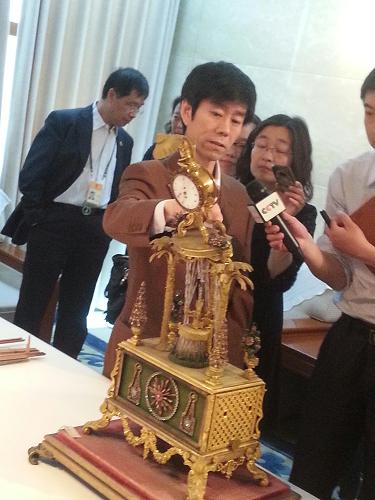 5月5日,故宮博物院宮廷部研究員郭福祥向記者介紹清代銅鍍金轉(zhuǎn)花水法人打鐘受損情況。新華社記者 廖翊 攝