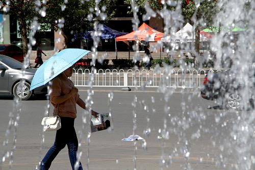 5月11日,一名市民撐傘行走在保定市街頭。 當(dāng)日,河北省大部分地區(qū)迎來高溫天氣。河北省氣象臺(tái)11日9時(shí)發(fā)布今年首個(gè)高溫橙色預(yù)警信號(hào),預(yù)計(jì)今明兩天,保定、石家莊、邢臺(tái)等中南部地區(qū)最高氣溫可達(dá)35℃以上,局部地區(qū)可達(dá)37℃以上,空氣濕度較低。氣象專家提醒廣大市民,外出時(shí)一定要注意做好防暑、防曬和補(bǔ)水工作。 新華社發(fā)(朱旭東 攝)