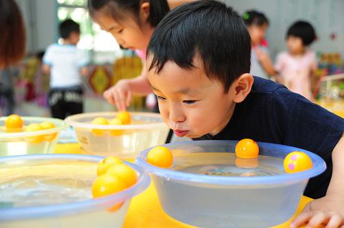 5月29日,天津市紅橋區(qū)第十八幼兒園的孩子在“樂(lè)樂(lè)游藝室”比賽吹乒乓球。在“六一”兒童節(jié)即將到來(lái)之際,天津多所幼兒園相繼開(kāi)展了形式多樣、趣味橫生的慶?;顒?dòng)。