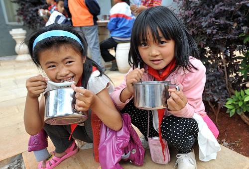 5月29日,長湖鎮(zhèn)中心小學(xué)兩名彝族女生在進(jìn)食午餐。