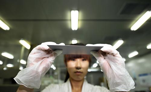 6月5日,天津英利新能源有限公司的員工在車間內(nèi)檢查切割后的硅片。新華社記者岳月偉攝