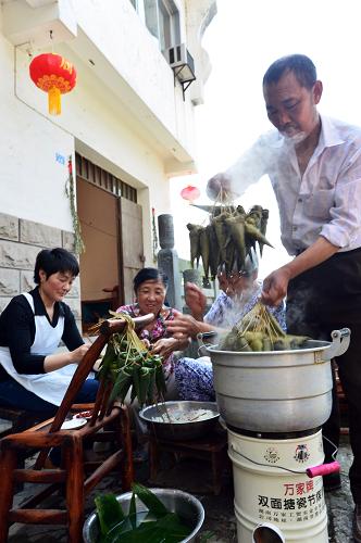 6月7日,在秭歸縣歸州鎮(zhèn)屈子街,居民在家門口包粽子。新華社發(fā)(鄭家裕 攝)