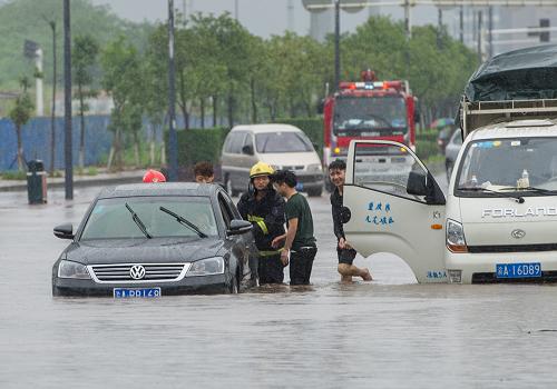 6月9日,在重慶市大學(xué)城城南大道,西永消防中隊(duì)的戰(zhàn)士幫助熄火車輛的駕駛員推車。新華社記者 陳誠(chéng) 攝