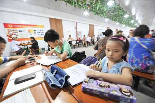 6月19日,幾名放高溫假的小學(xué)生在重慶市渝北區(qū)大龍山人防工程納涼點(diǎn)內(nèi)寫作業(yè)。新華社記者 劉潺 攝