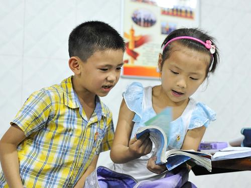 6月19日,兩名放高溫假的小學(xué)生在重慶市渝北區(qū)大龍山人防工程納涼點(diǎn)內(nèi)讀書。新華社記者 劉潺 攝