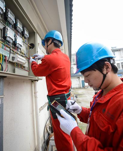 6月20日,浙江長興縣供電局搶修人員在和平鎮(zhèn)和平村用平板電腦向指揮中心上報(bào)實(shí)時搶修情況。新華社記者 徐昱 攝
