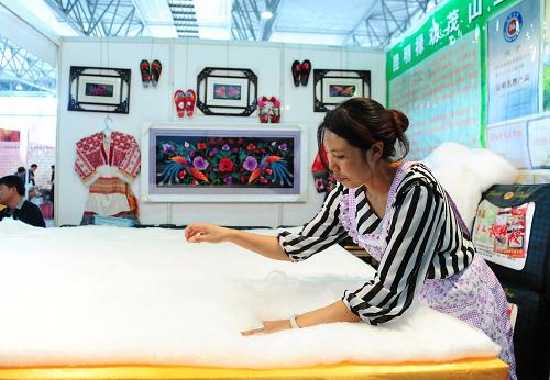 6月20日,昆明市祿勸縣一家企業(yè)工人現(xiàn)場制作蠶絲被。新華社記者 秦晴 攝